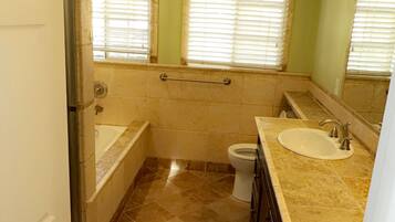 A bathroom with a bathtub, toilet, and sink.