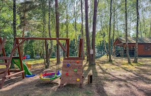 Ein Spielplatz mit Schaukel, Rutsche und Klettergerüst.