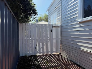 A fenced backyard with a paved patio area. - South Beach Hideaway Studio- Close to Beach (South Fremantle)