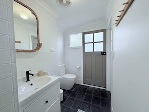 A bathroom with a white sink, mirror, and toilet. - South Beach Hideaway Studio- Close to Beach (South Fremantle)