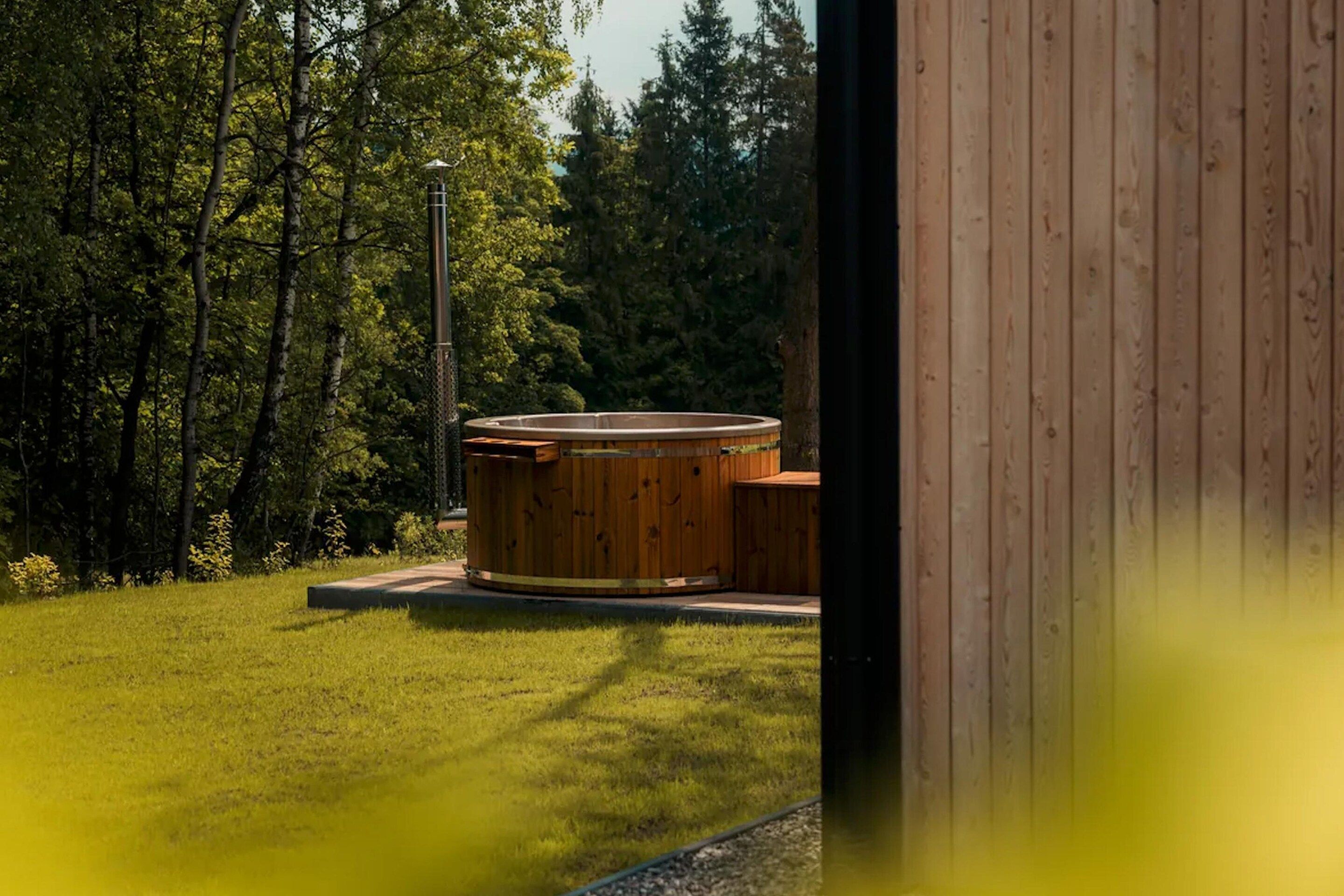 A hot tub in a grassy area with trees in the background.