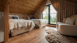 Un dormitorio acogedor en el ático con dos camas, un sofá y un ventanal grande.