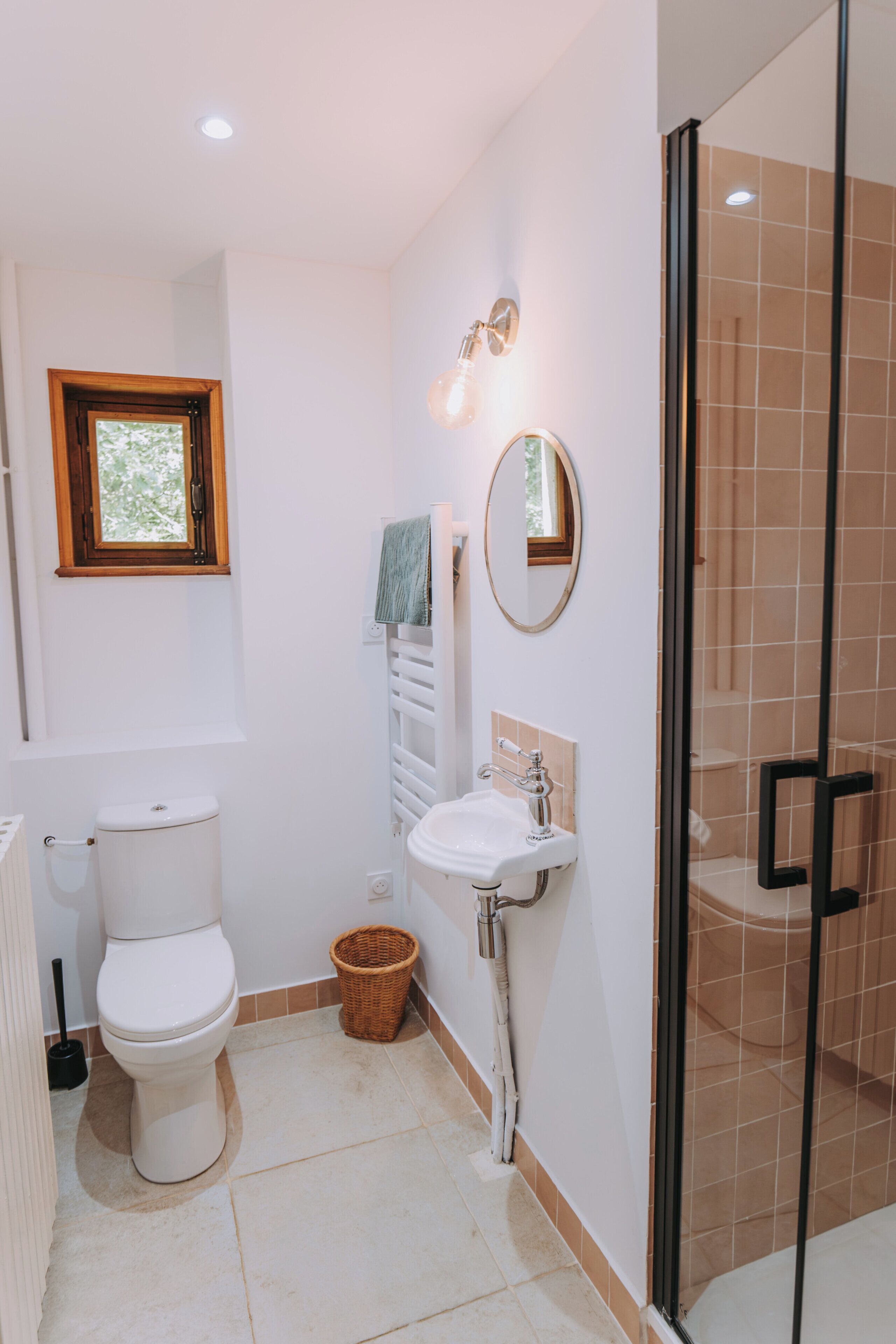 Une salle de bain avec des toilettes, un lavabo et une douche.