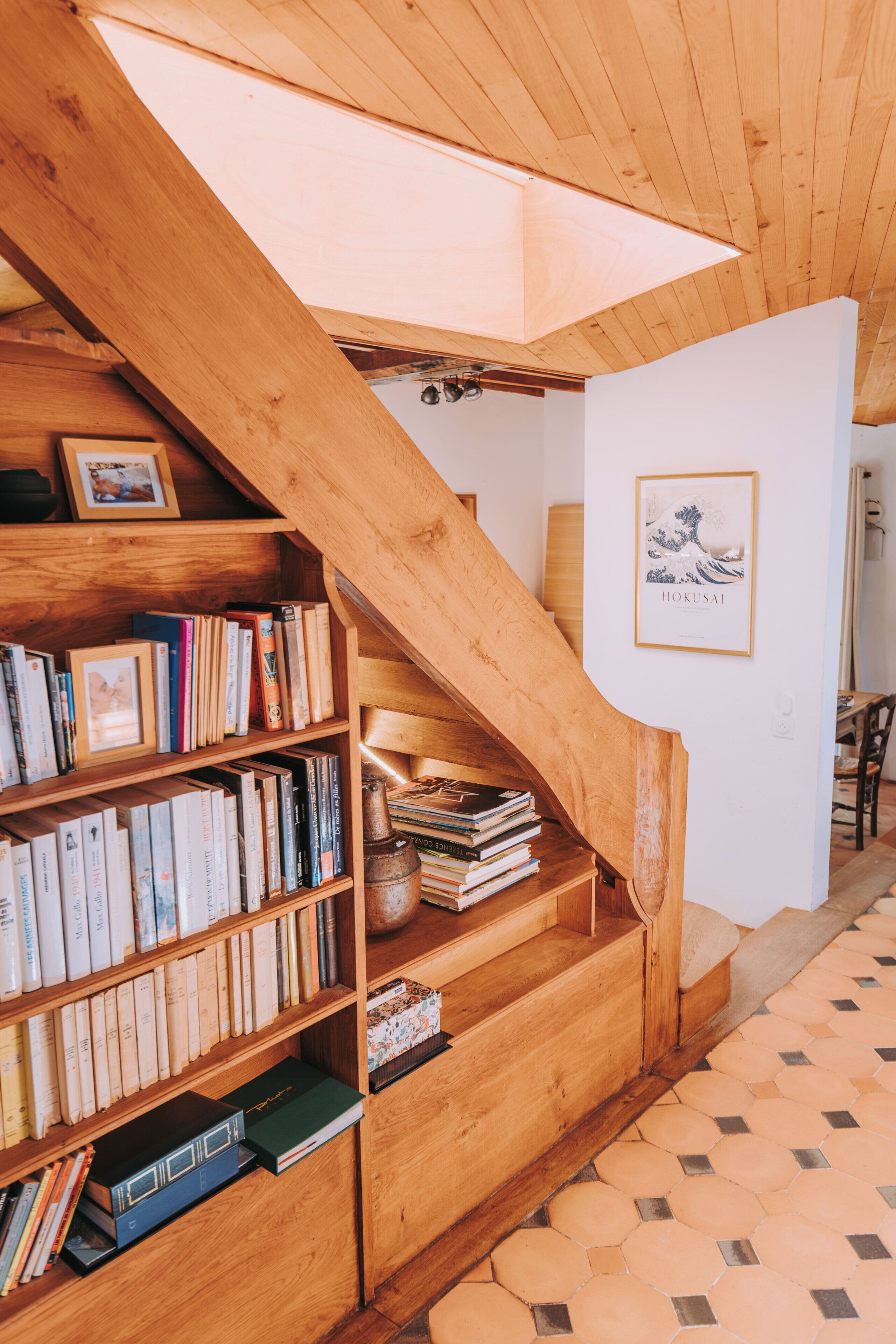 A wooden staircase with bookshelves on either side, leading to an upper level.