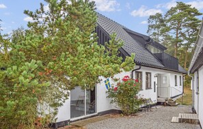 A house with a sloped roof, a visible window, and a flag. - 3 bedroom amazing home in Borrby (Borrby)