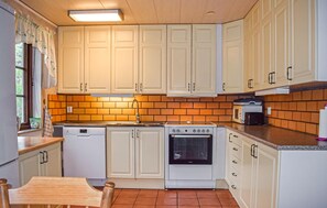 A kitchen with white cabinets, a stove, a microwave, and a dishwasher. - 3 bedroom amazing home in Borrby (Borrby)