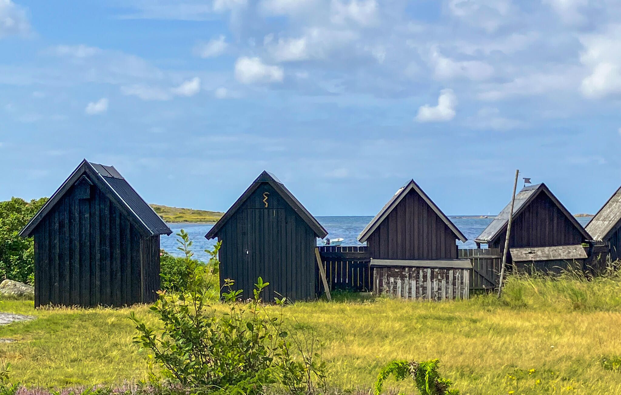 Une rangée de constructions en bois avec vue sur la mer.