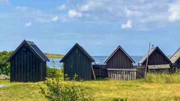 A row of wooden structures with a view of the sea.