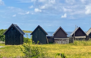 A row of wooden structures with a view of the sea.