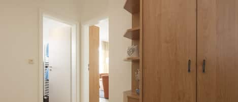 A hallway with wooden cabinets and a door leading to another room.