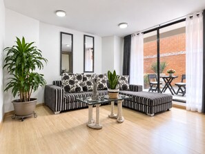 A modern living room with a sofa set, a coffee table, and a potted plant. - Apartment 2, Parque de la 93. (Bogotá)