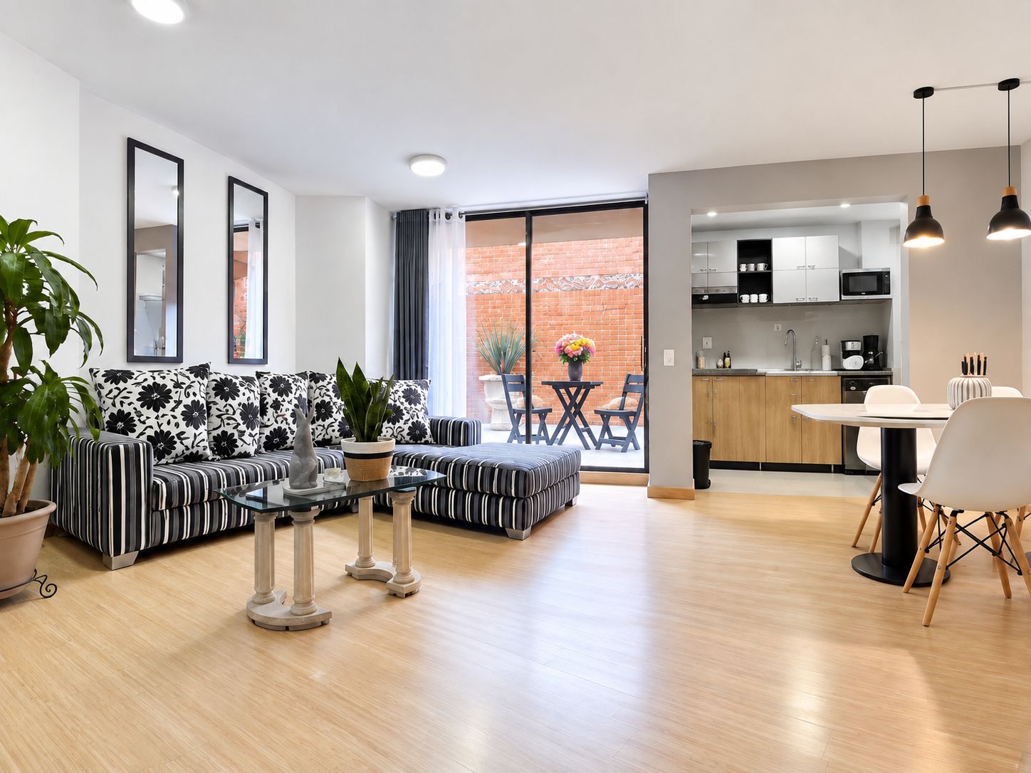 A modern living room with a sofa, coffee table, and dining area.