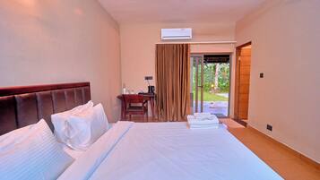 Habitación de hotel con una cama grande, un escritorio y vistas al exterior.