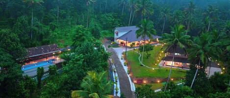A resort with multiple buildings, a swimming pool, and a well-maintained garden.
