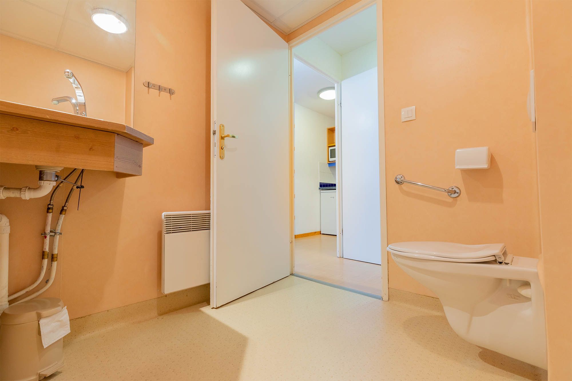 Ein Badezimmer mit Toilette, Waschbecken und Duschbereich.