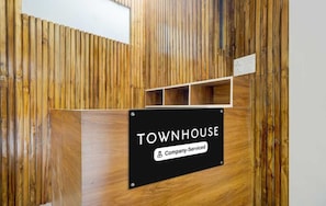 Eine Rezeptionstresen mit einem Schild, auf dem 'TOWNHOUSE Company-Serviced' steht.