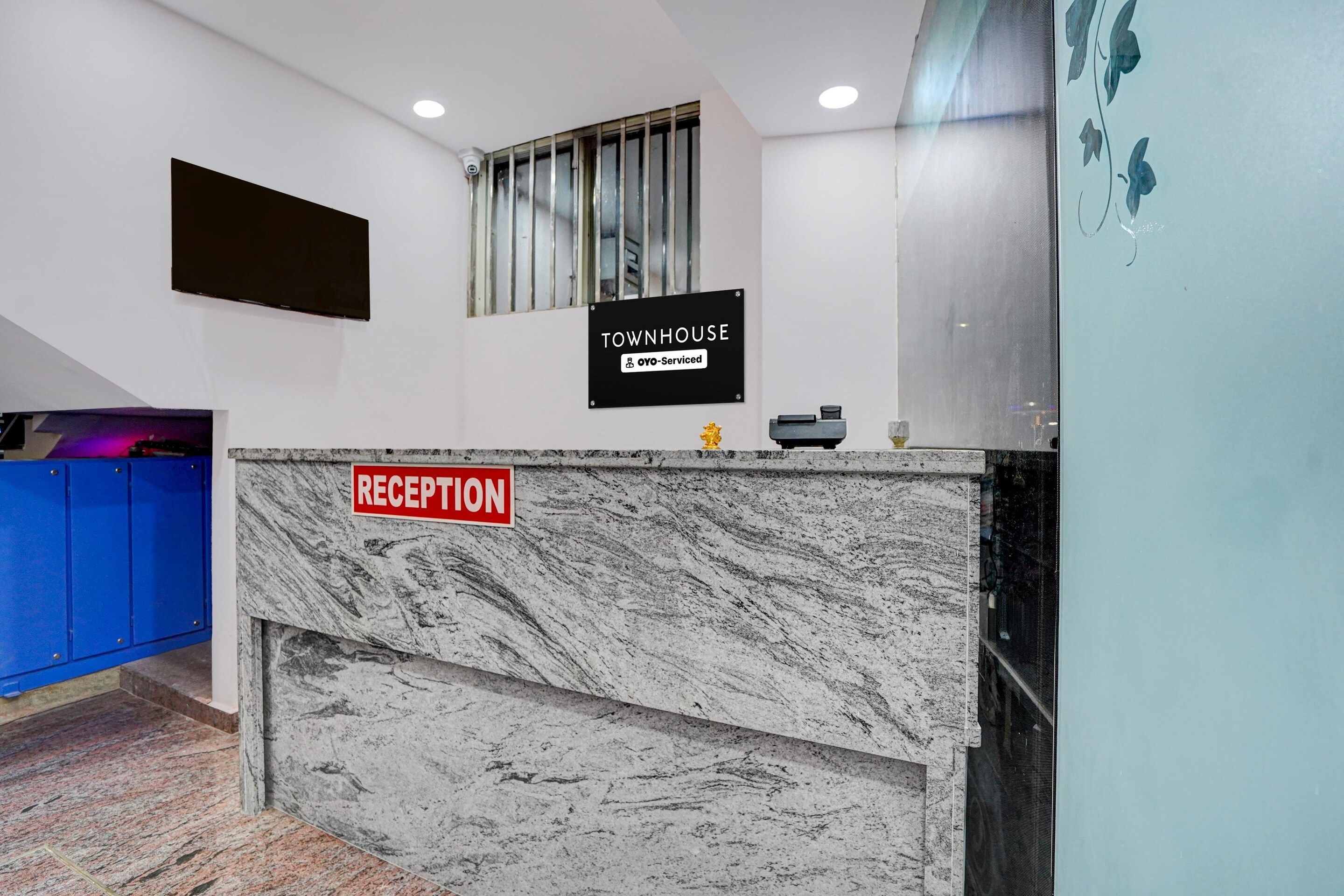 A reception desk with a marble top and a sign indicating it is serviced by OYO.