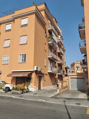 A multi-story residential building with balconies, air conditioning units, and a storefront labeled 'ALIMENTARI'. - Easy Metro Apartment Rome Boccea (Roma)