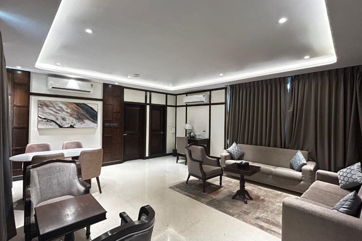 Una sala moderna con sofá, sillones, una mesa de centro y un comedor con mesa y sillas.