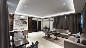Una sala moderna con sofá, sillones, una mesa de centro y un comedor con mesa y sillas.