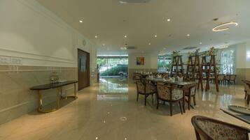 A spacious dining area with a long table, chairs, and a buffet setup.