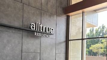 A reception desk with a marble top and a sign that reads 'alltrue RESIDENCE'.