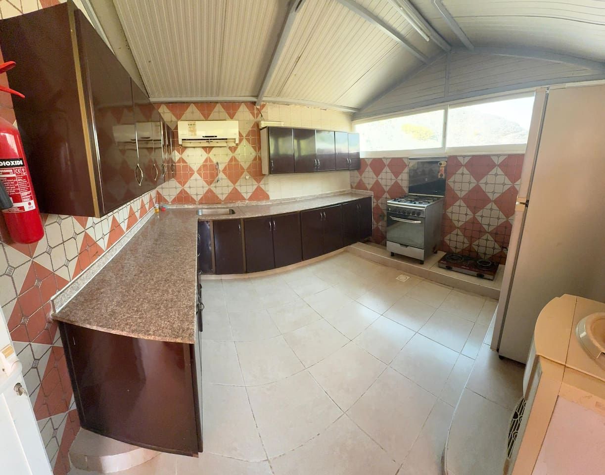 A compact kitchen with a gas stove, a sink, and cabinets.
