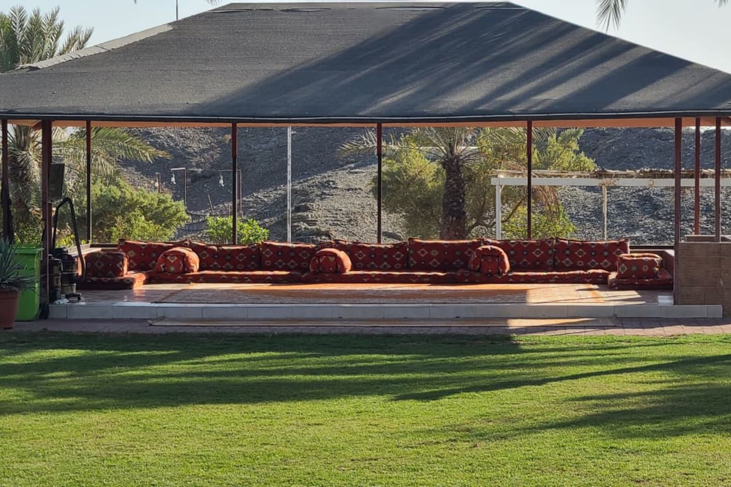 A covered outdoor seating area with a view of a mountainous landscape.