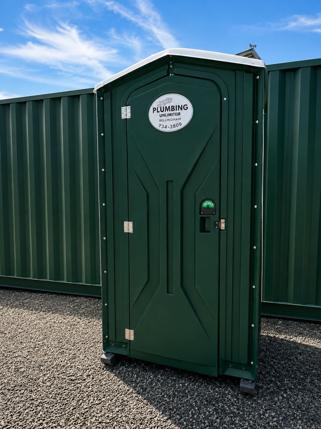 Eine grüne mobile Toilette mit einem Schild, das anzeigt, dass sie für Sanitärdienste vorgesehen ist.