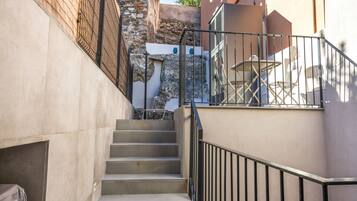 Una escalera que lleva a un balcón con muebles de exterior.