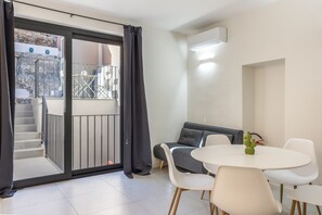 A modern living room with a balcony, a sofa, a dining table with chairs, and a cactus decoration. - Calcagno Home vacation house with private terrace, Wi-Fi, and air conditioning (Milazzo)
