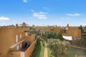 A courtyard with buildings, a pathway, and greenery. - Casa Tartessos with Pool and Parking in Costa Ballena (Rota)