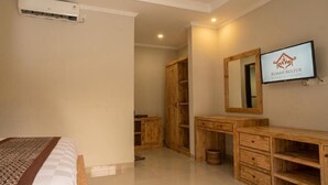 Un dormitorio con cama, armario de madera, televisor y espejo.
