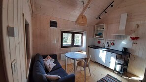Un espacio habitable funcional con sofá, mesa de comedor y kitchenette.