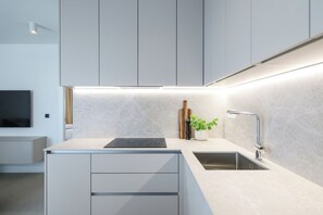 A modern kitchen with a built-in stove, a sink, and a countertop. - Apex Refined Apartment Antun Zadar (Zadar)