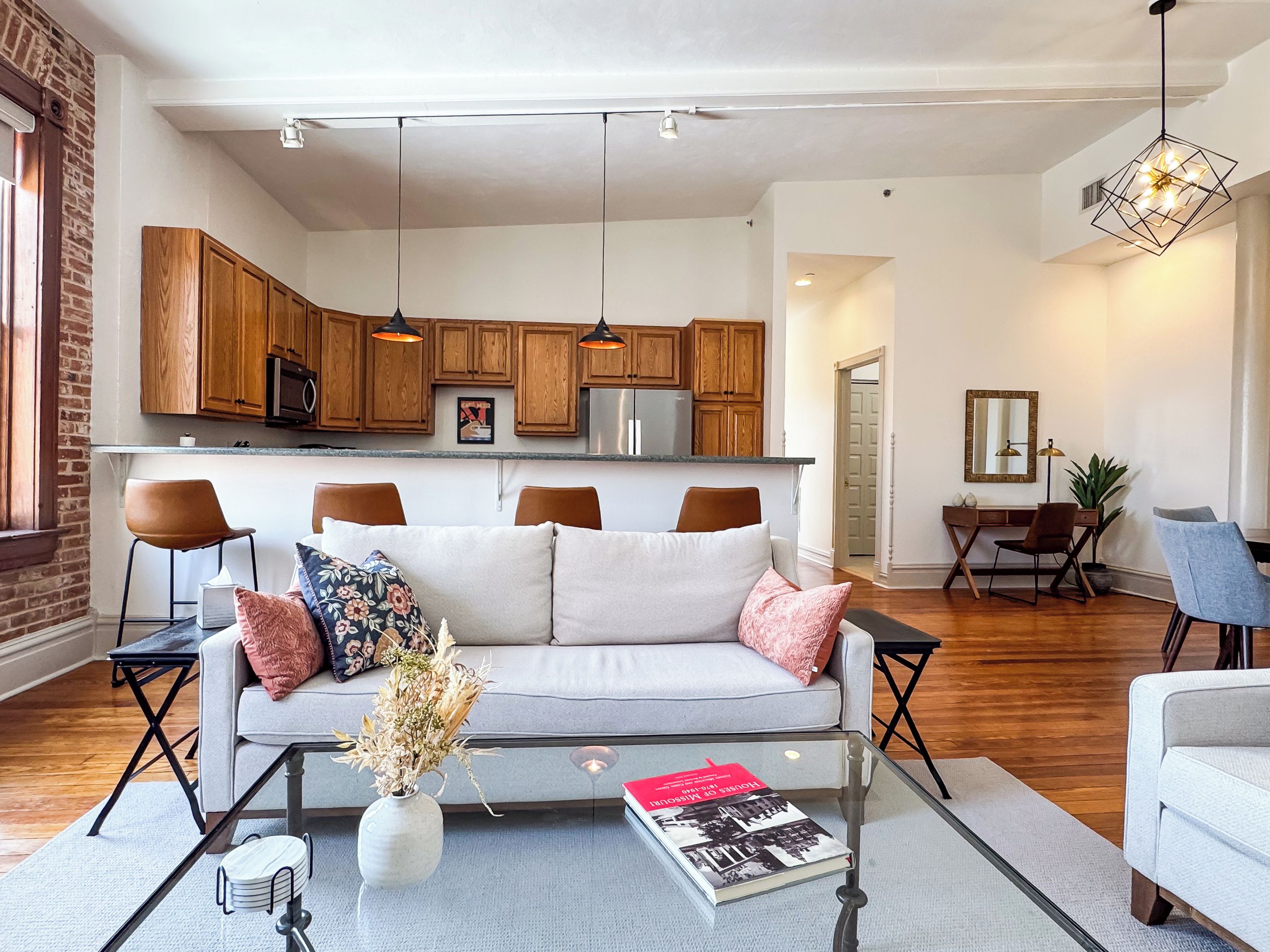 Een moderne woonkamer met een bank, salontafel en een eethoek met stoelen en een tafel.