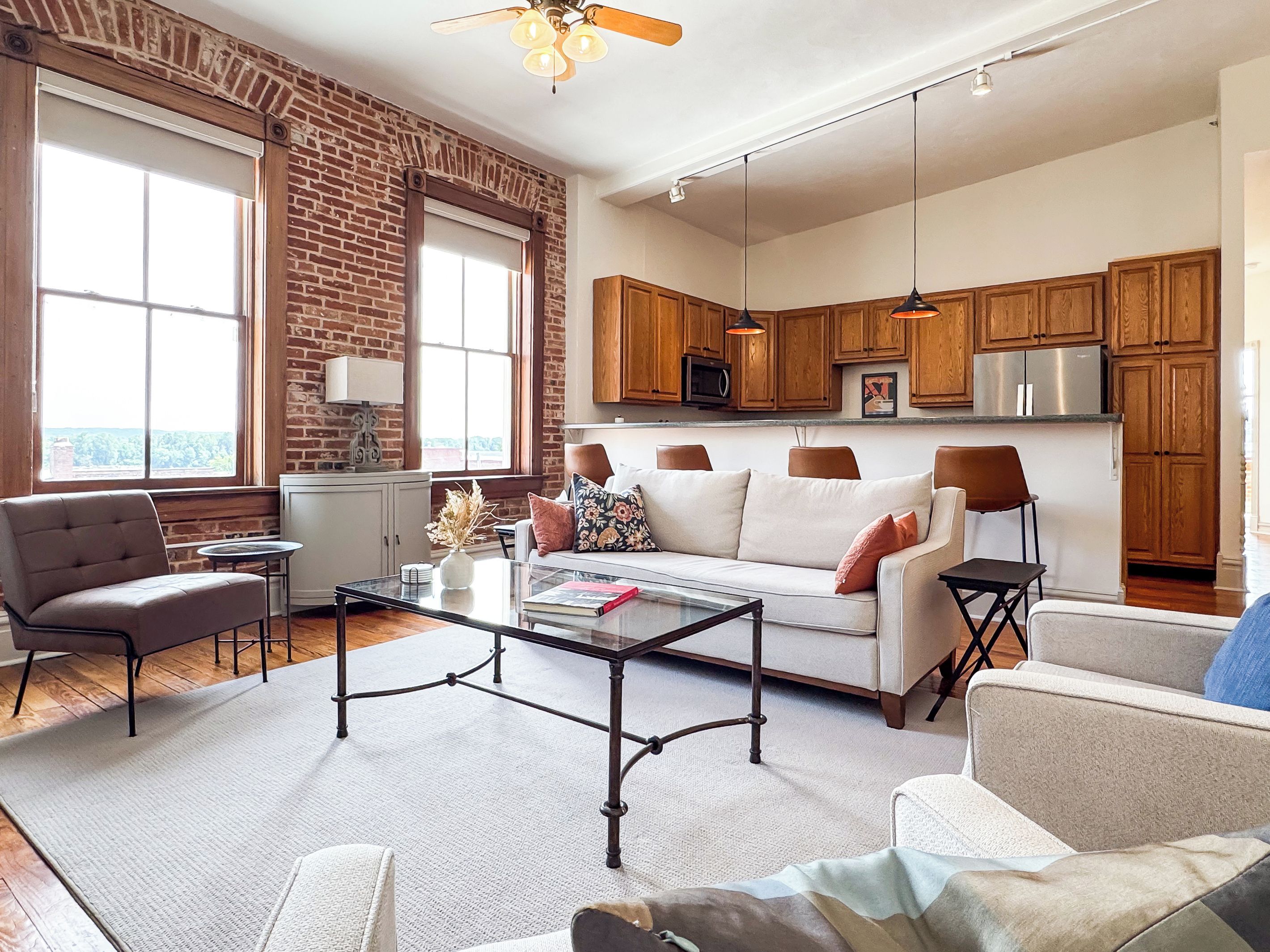 A modern living room with a sofa, armchairs, a coffee table, and a fireplace.