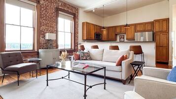 A modern living room with a sofa, armchairs, a coffee table, and a fireplace.