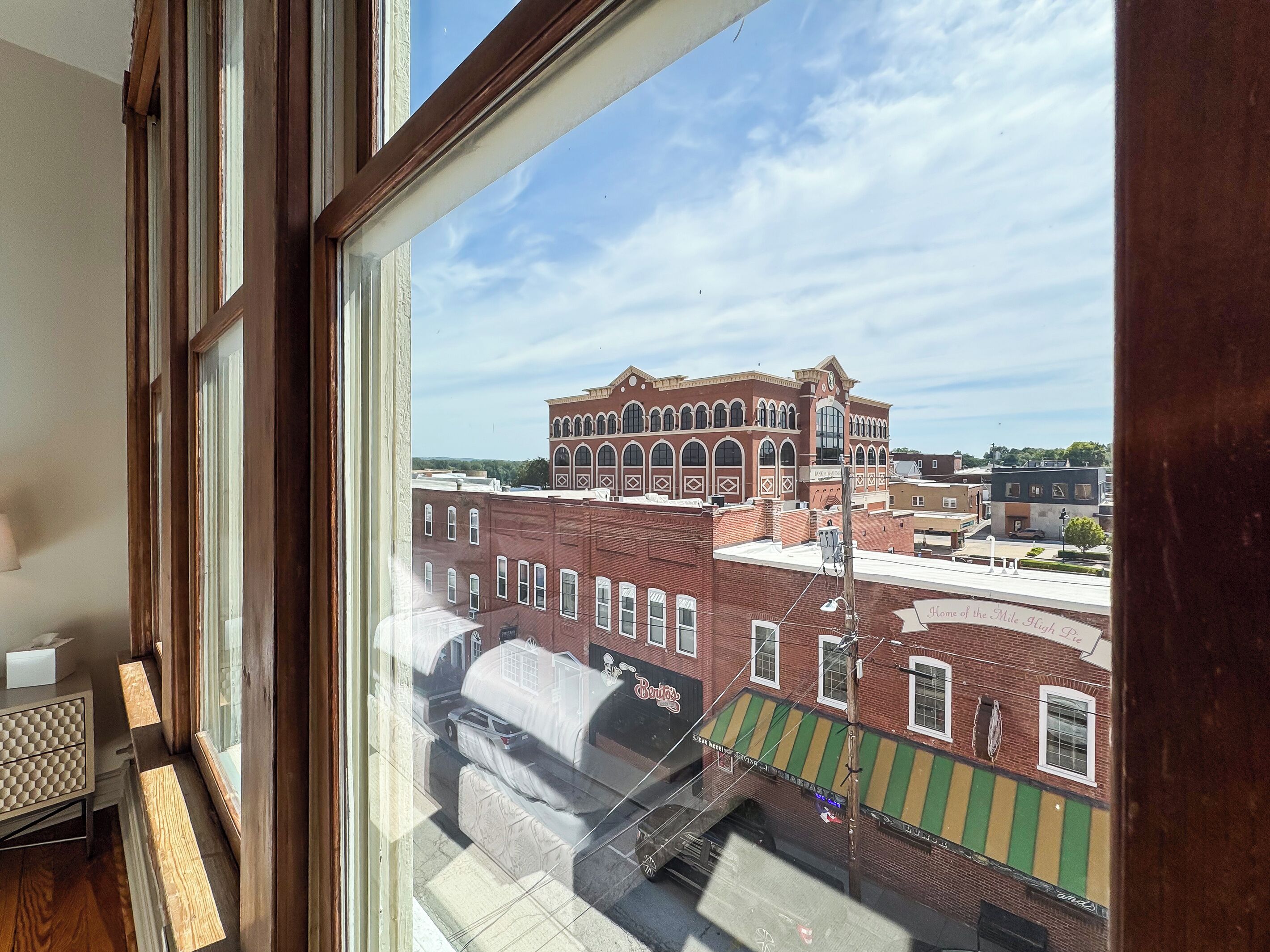 A room with a large window overlooking a historic building with arched windows and a clock tower.