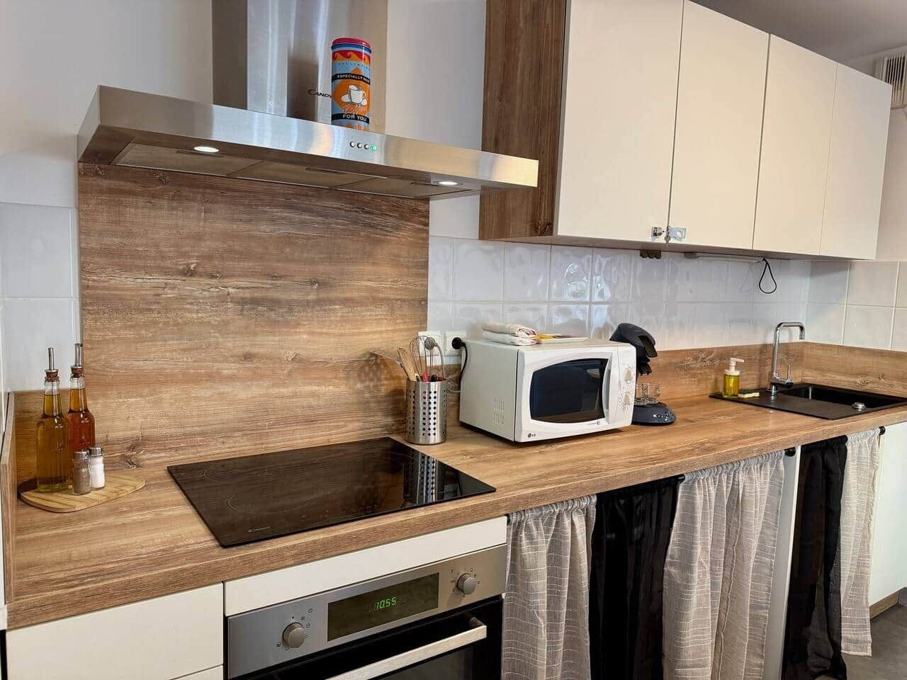 Une cuisine équipée d’un four à micro-ondes, d’un grille-pain et d’un plan de travail en bois.