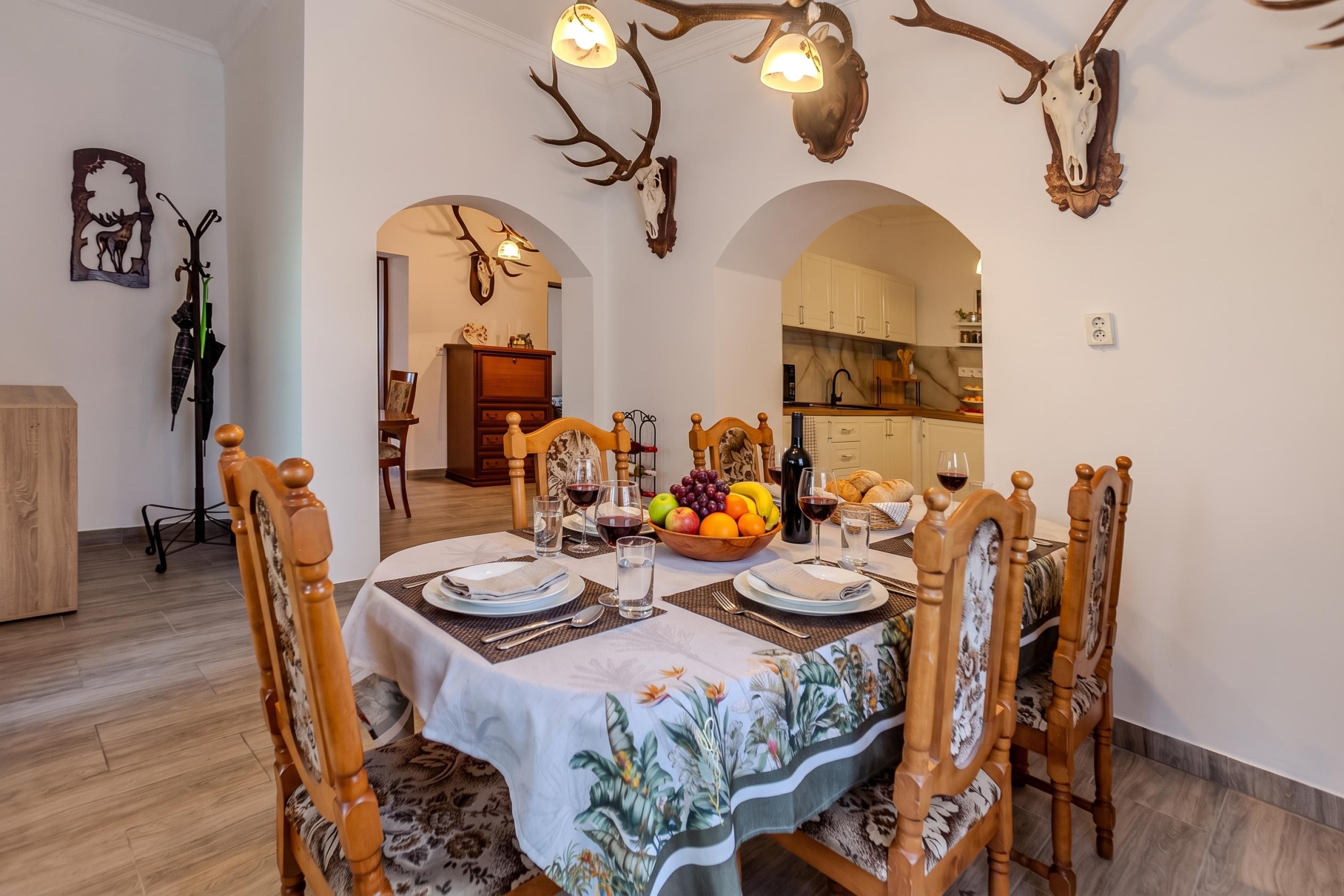 A dining area with a table set for four, surrounded by wooden chairs with carved details.