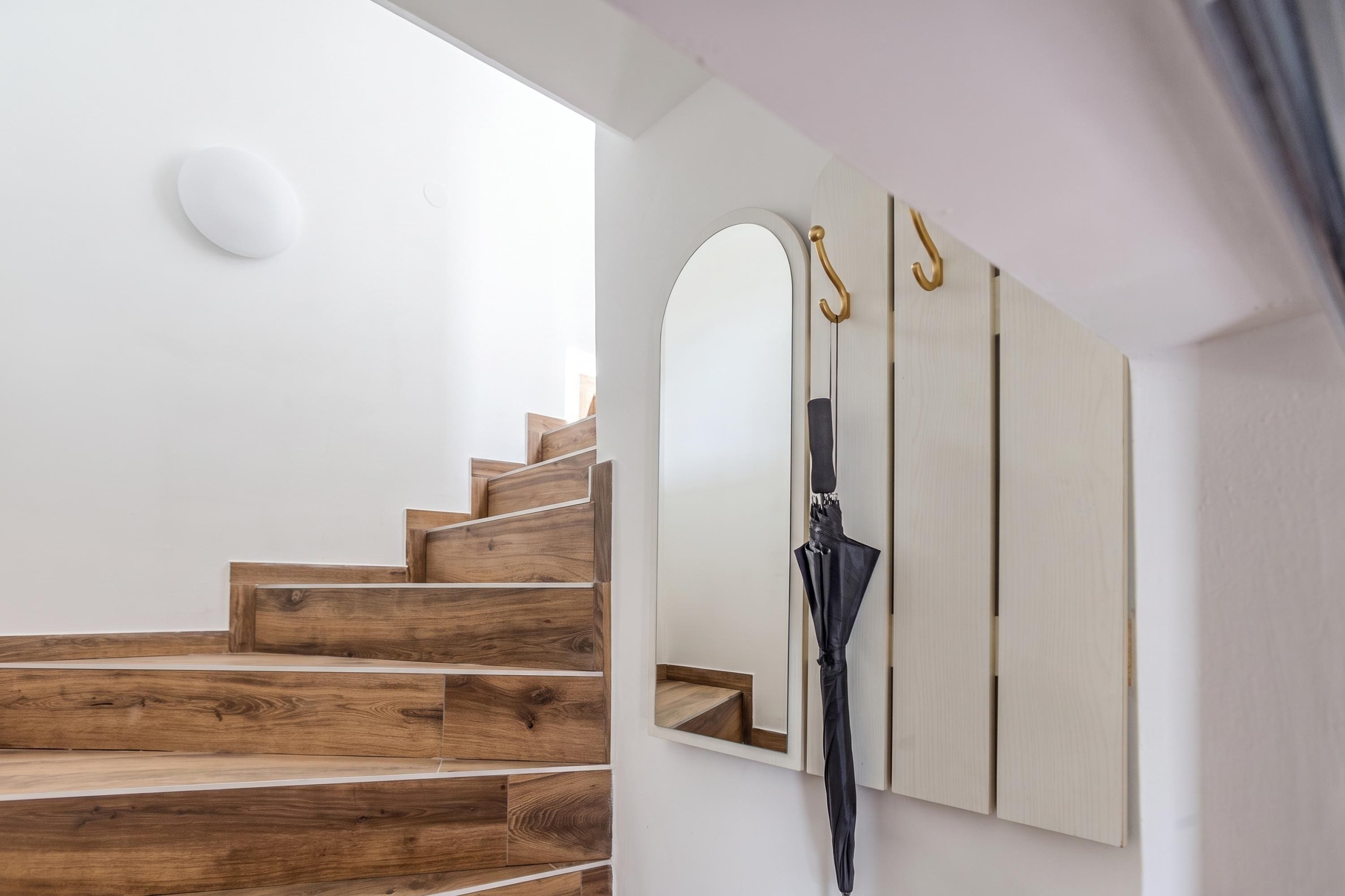 A staircase with wooden steps and a white wall.