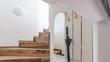 Una escalera con escalones de madera y una pared blanca.