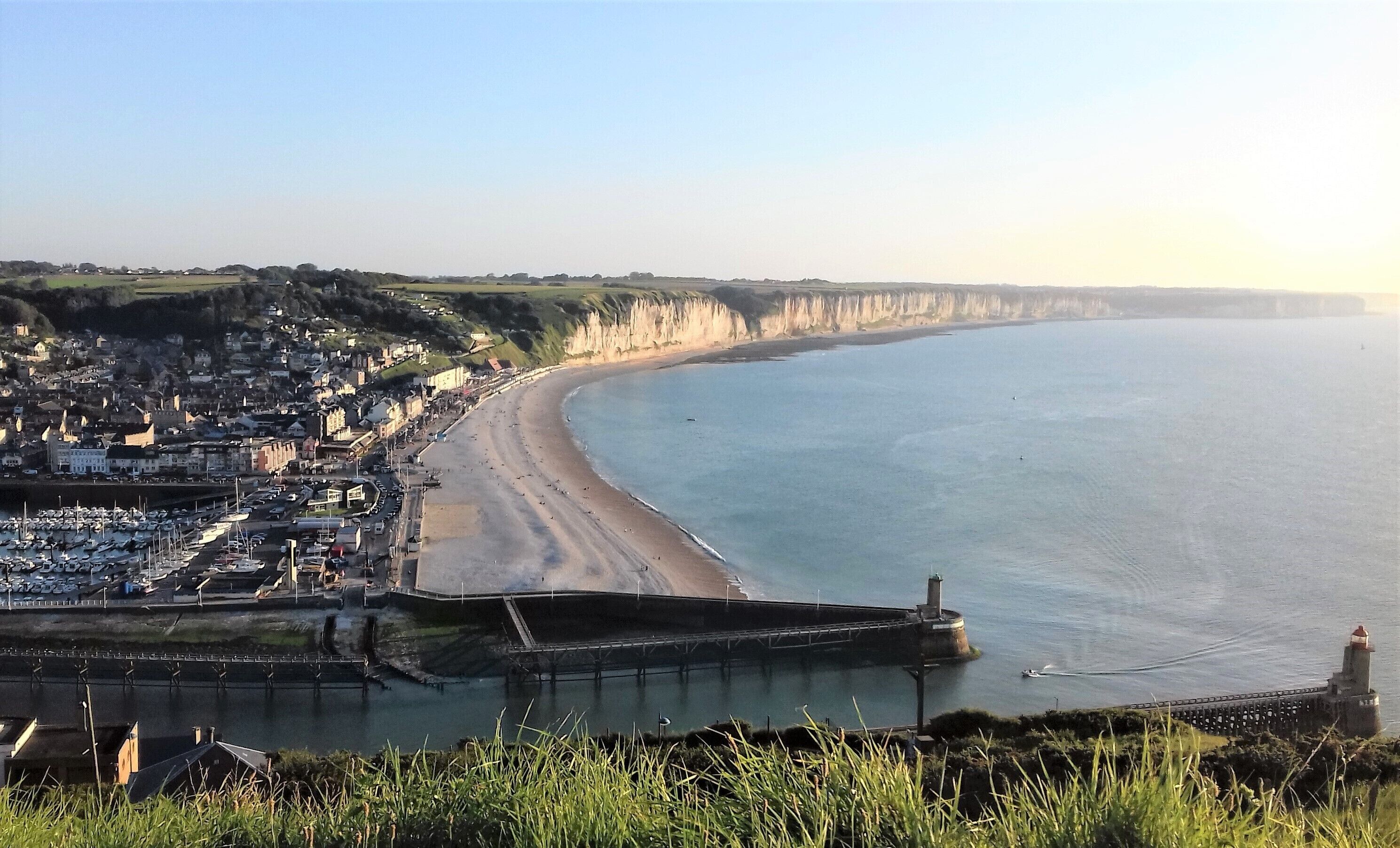 Une ville côtière dotée d’une plage, d’un port de plaisance et d’un phare.