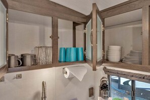 Ein Badezimmer mit Handtuchhalter, Toilettenpapierhalter, Spiegel und einer Kaffeemaschine.