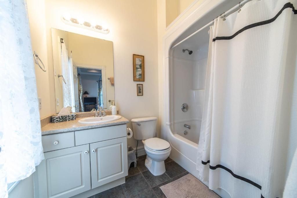 Un baño con lavamanos, inodoro y bañera.