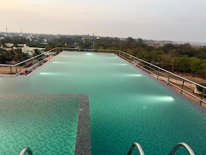 Une piscine à débordement située sur le toit, offrant une vue dégagée sur le paysage urbain.