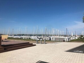 A marina with numerous sailboats docked, a paved walkway, and a bicycle parking area. - Holiday Apartment With 1 Bedroom (Grossenbrode)