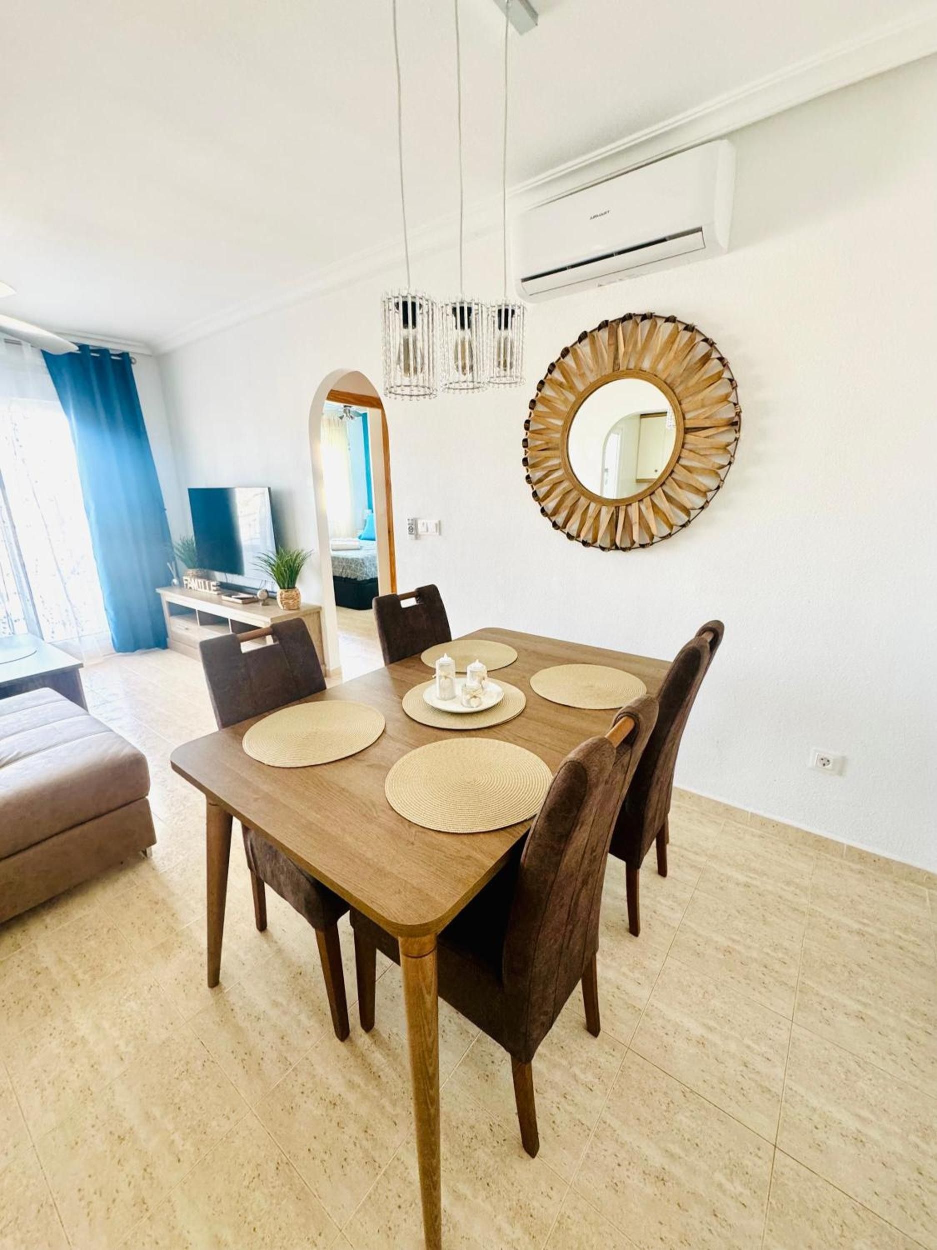 A dining area with a wooden table, chairs, and a decorative mirror.