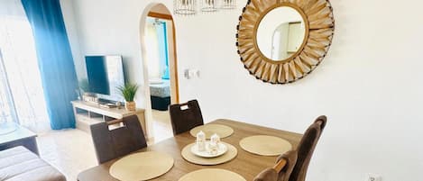 A dining area with a wooden table, chairs, and a decorative mirror.